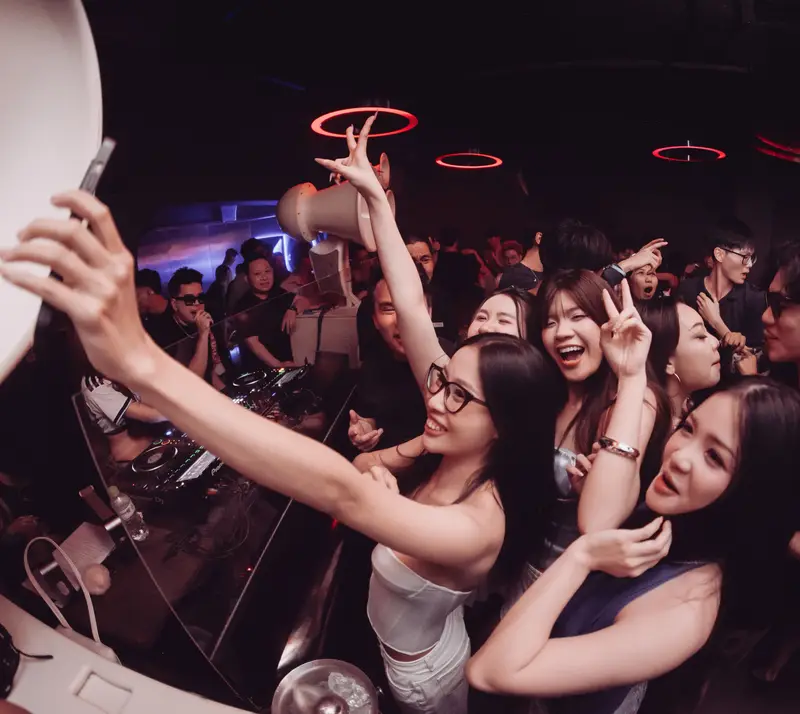Nhóm khách chụp ảnh cùng DJ ngay cạnh bàn mix tại LOCO Heatroom